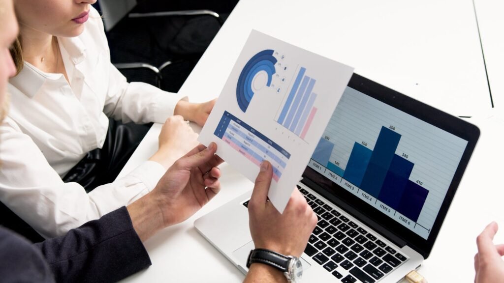 Business professionals discussing data charts and graphs in a modern office setting, Why most investing advice online is useless