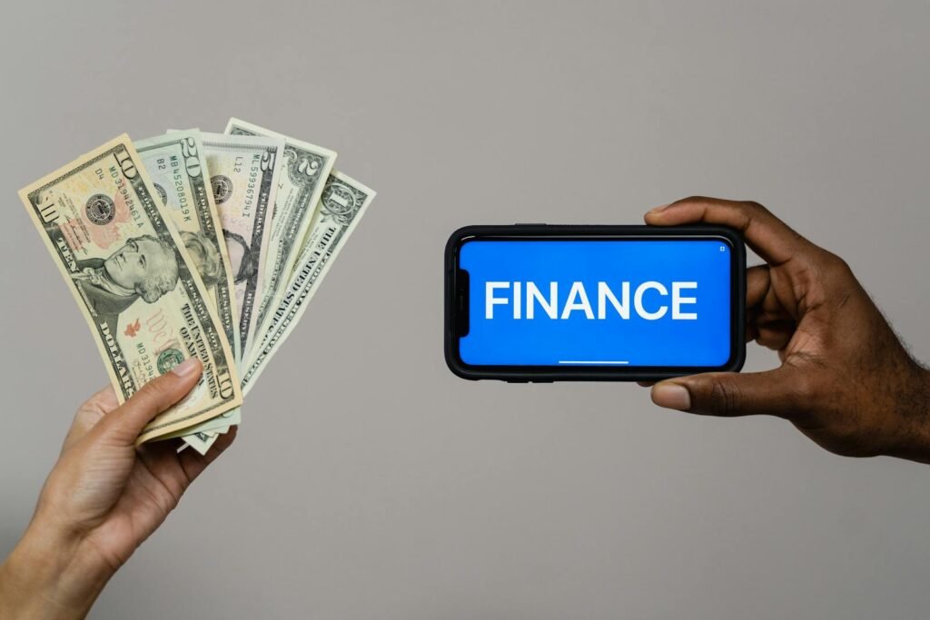 Image depicting currency and finance concept with hands holding cash and a smartphone. Toxic money mindsets that keep you broke